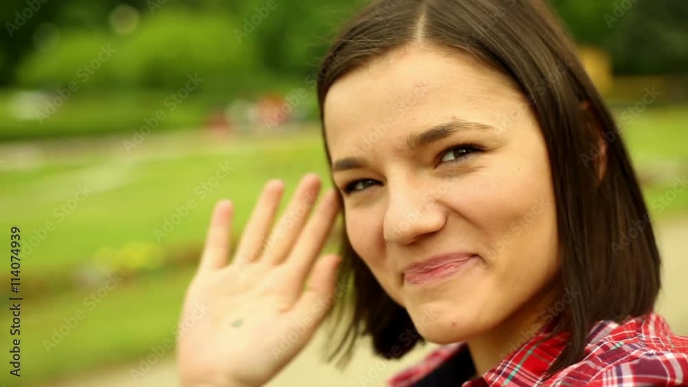 Cute woman in the park waving
