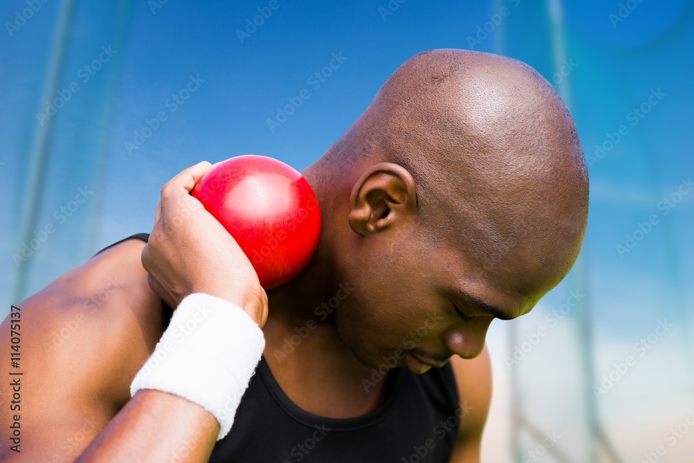 Composite image of portrait of sportsman practising shot put 