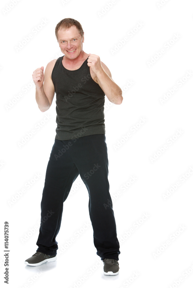 A fifty year old man in a track suit took a boxer's stance-Isolated on white background
