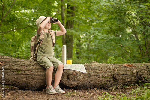 girl looking at birds through binoculars, camping in the woods
