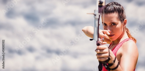 Fototapeta Naklejka Na Ścianę i Meble -  Composite image of portrait of sportswoman practising archery 