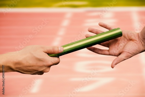 Composite image of  man passing the baton to partner on track