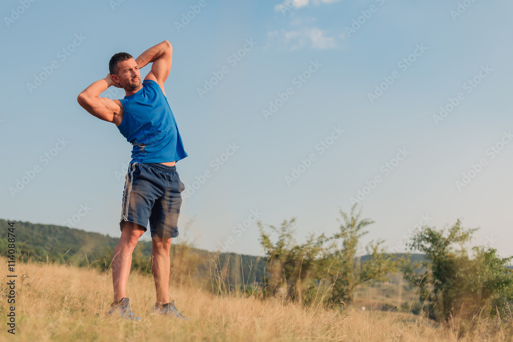 Attractive athletic man in his 30s stretching outdoor preparing for exercise