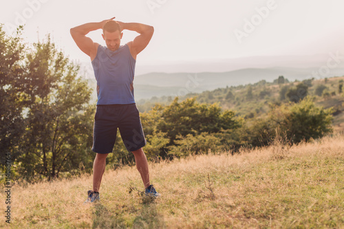 Attractive athletic man in his 30s stretching outdoor preparing for exercise