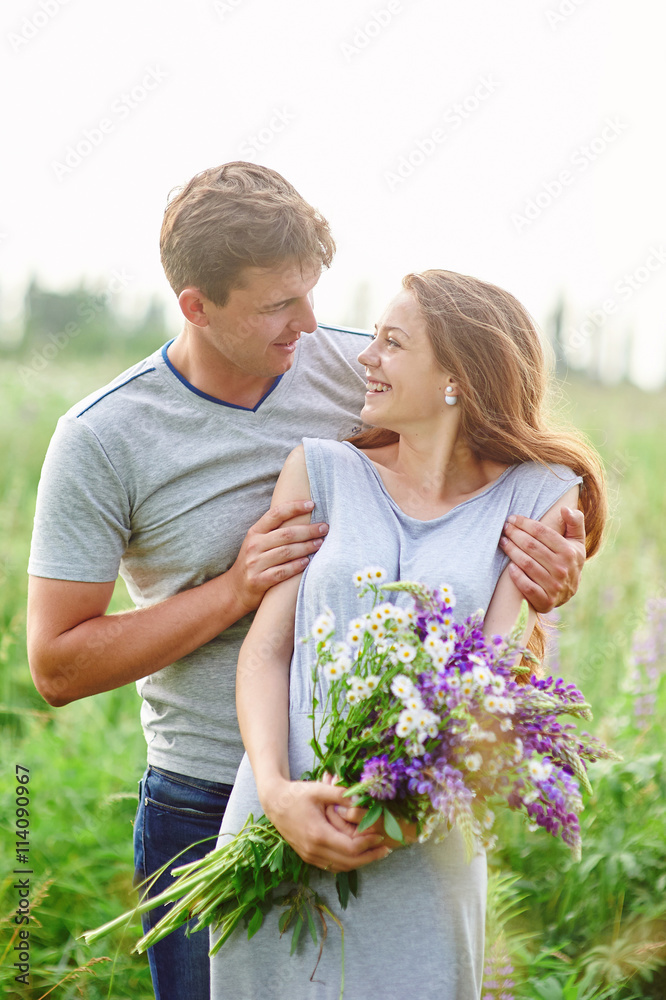 happy couple playing with each other in a field bouquet of lupines happy couple playing with each other in a field bouquet of lupines