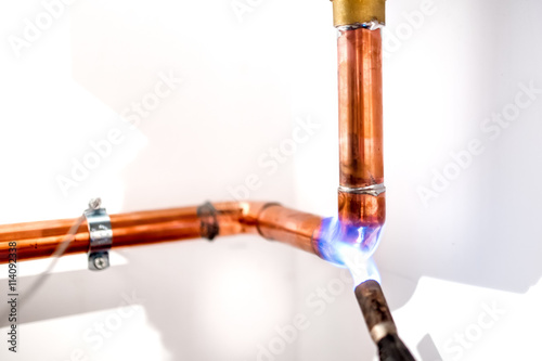 Bild auf Leinwand industrial plumber using blowtorch, propane gas torch for welding copper pipes