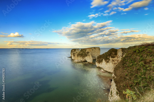 White cliffs at Dorset coast ranging into emerald colored sea. Old Harry Rocks
