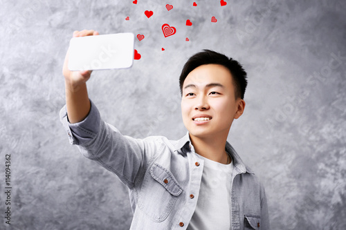 Young Asian boy holding sma...