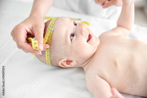 Professional pediatrician examining smiling baby photo