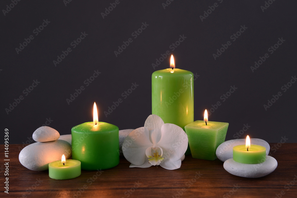 Spa stones with burning candles and flower on grey background Spa stones with burning candles and flower on grey background