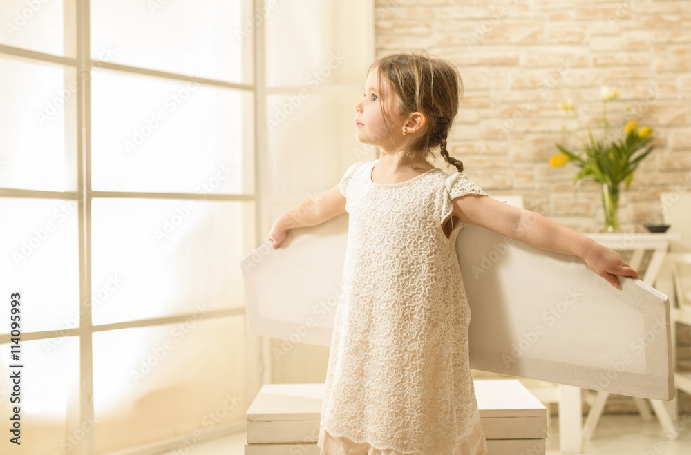 Little child girl plays astronaut. Child in an astronaut costume plays and dreams of becoming a spaceman. Children's play concept Little child girl plays astronaut. Child in an astronaut costume plays and dreams of becoming a spaceman. Children's play concept
