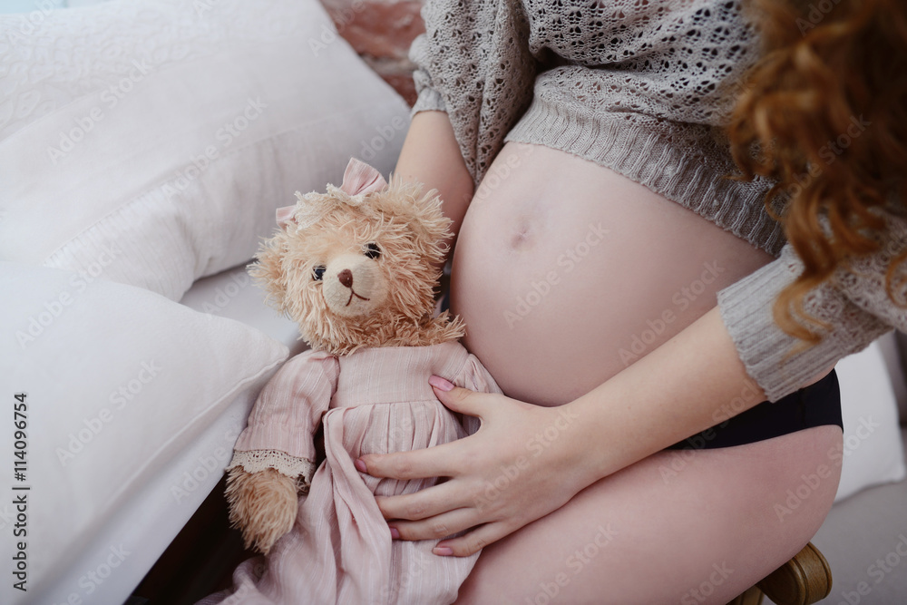 Beauty pregnant woman indoors. Female portrait of cute lady. Close-up beautiful model girl in elegant pose Beauty pregnant woman indoors. Female portrait of cute lady. Close-up beautiful model girl in elegant pose