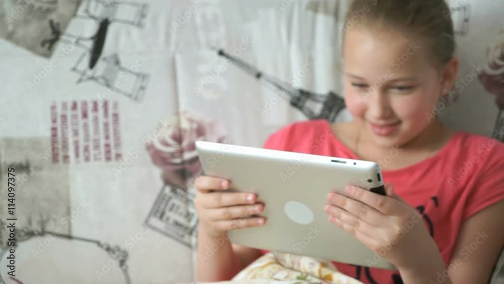 Child reading a digital tablet lying on the bed Child reading a digital tablet lying on the bed