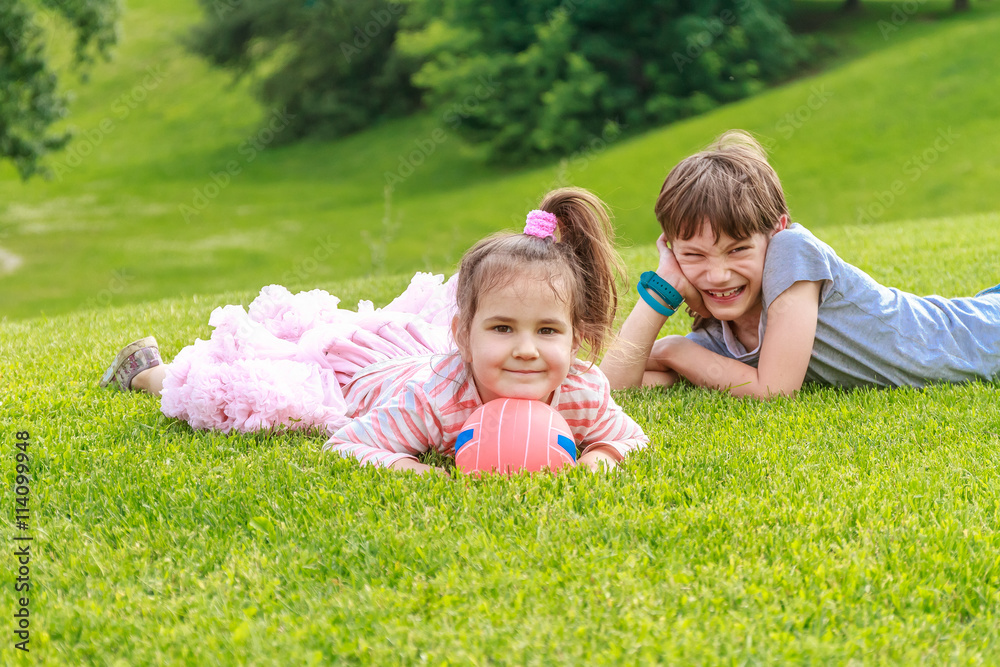Adorable young children, boy and girl, in the park. On warm summ Adorable young children, boy and girl, in the park. On warm summ