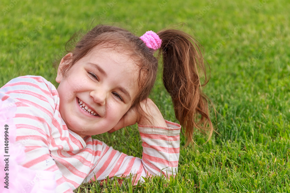 Obraz premium Adorable young child girl in the park. On warm summer day during
