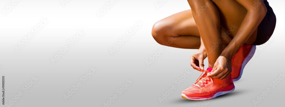 Composite image of close up of sportswoman is lacing shoes 
