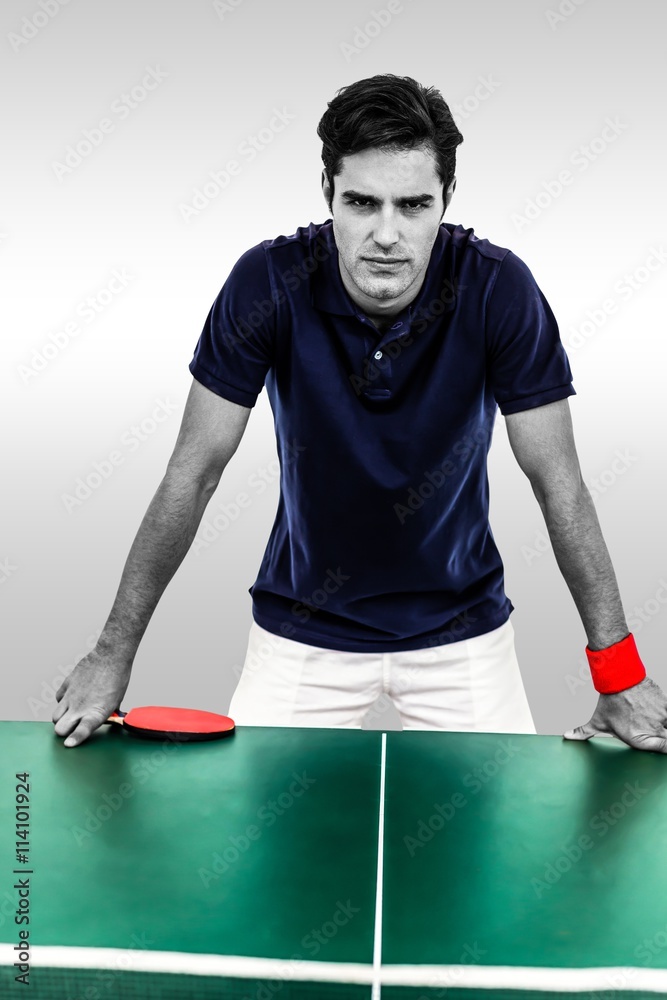 Composite image of confident male athlete leaning on hard table Composite image of confident male athlete leaning on hard table