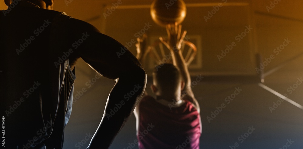 Fototapeta premium Rear view of a player shooting a basketball