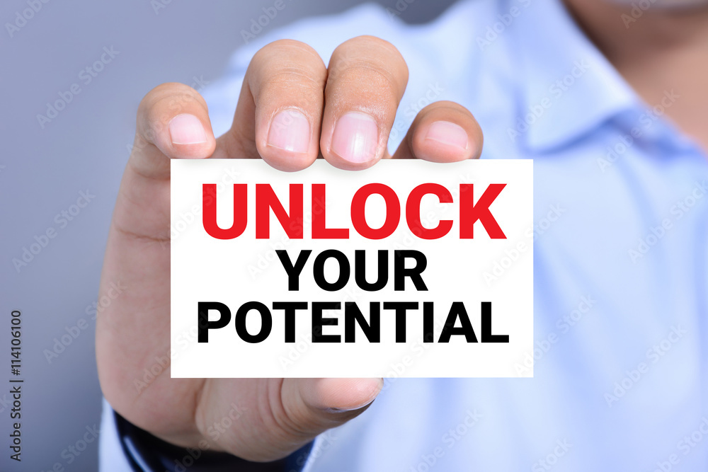 Hand showing card with message UNLOCK YOUR POTENTIAL Hand showing card with message UNLOCK YOUR POTENTIAL