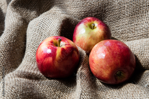 Fresh juicy apples on jute bag