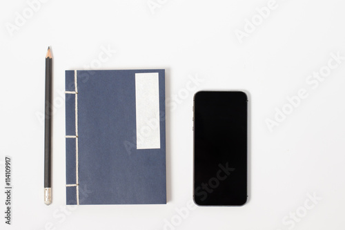 vintage notebook with pencil and smartphone