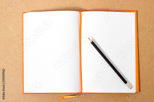 blank notebook with pencil on wooden table
