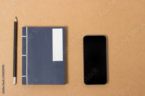 vintage notebook with pencil and smartphone