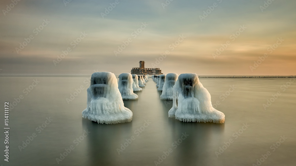 Obraz na plátně Frozen wooden breakwaters line to the world war II torpedo platform at Baltic Se