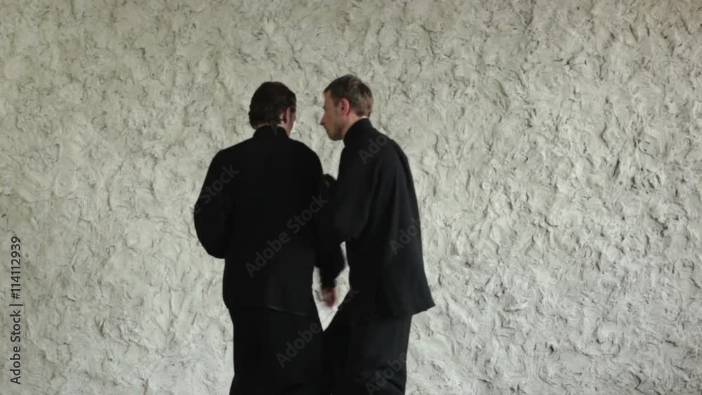 Training in the hall. Two men practicing the elements of tai chi