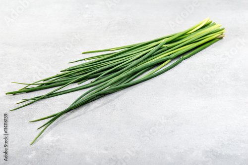 Fresh green chives on grey background
