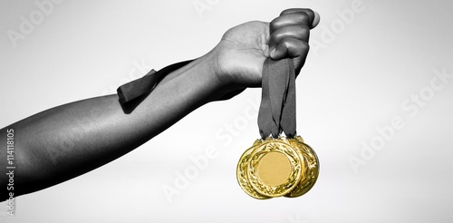 Fototapeta Hand holding three gold medals