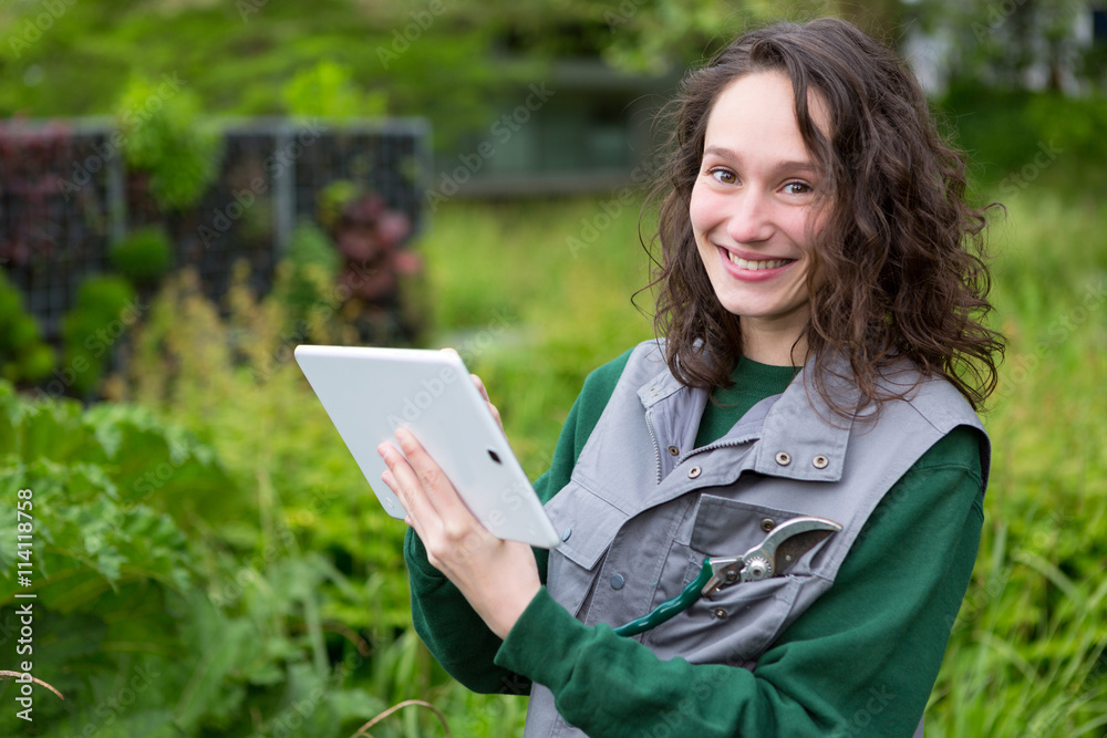 Young attractive woman working in a public garden using tablet Young attractive woman working in a public garden using tablet