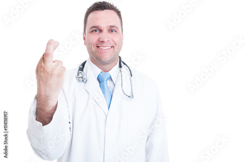 Male doctor smiling and showing fingers crossed with one hand