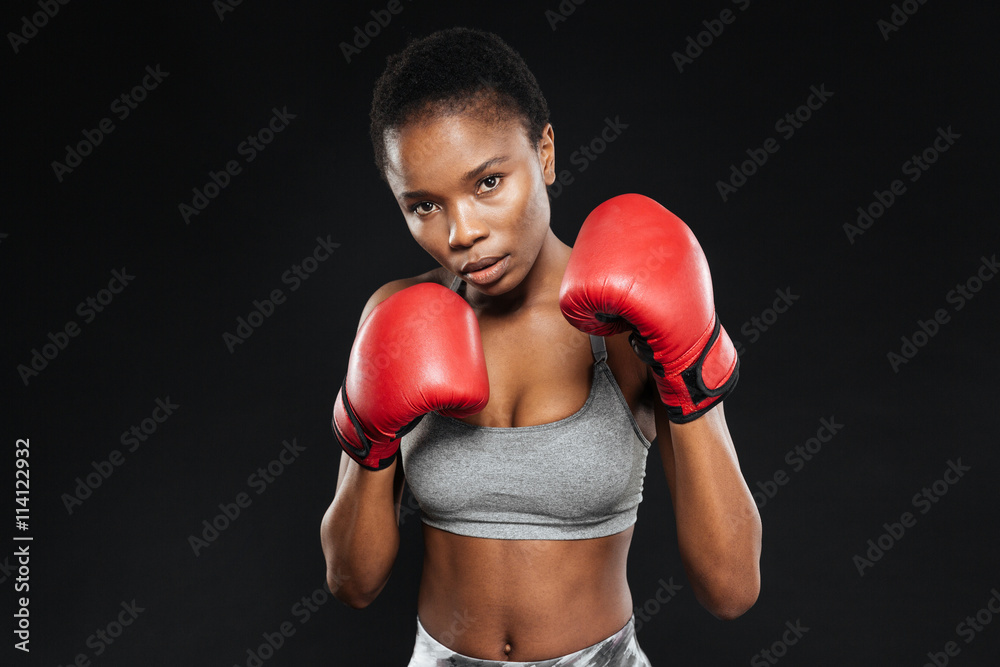 Fitness girl in boxing gloves fighting on black background Fitness girl in boxing gloves fighting on black background