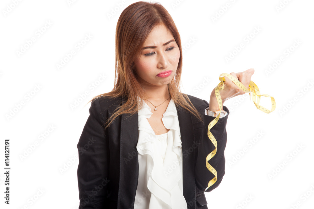 Unhappy young Asian business woman with measuring tape Unhappy young Asian business woman with measuring tape