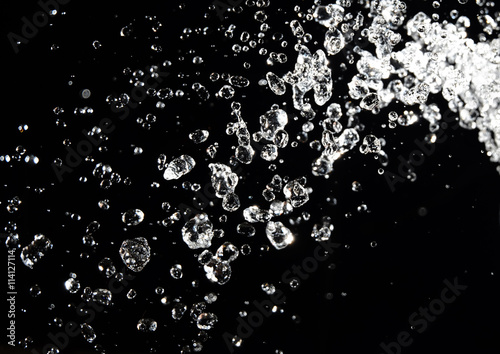 Water splash isolated on black background. drops levitate in the air dark