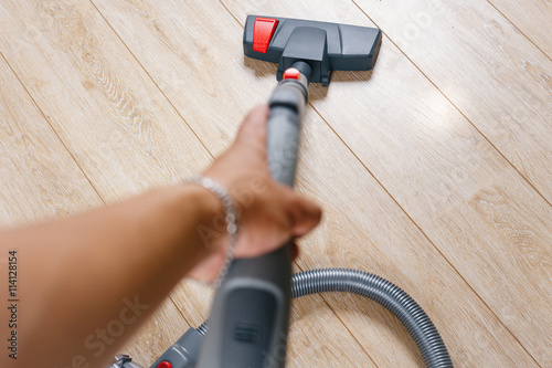The vacuum cleaner cleans floor house on the laminate