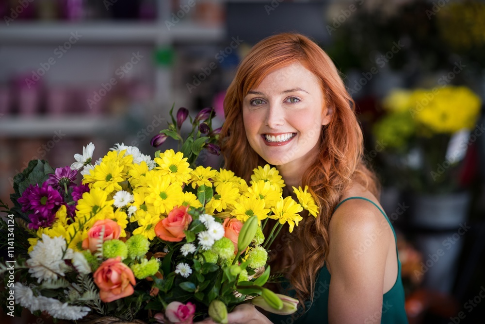 Happy female florist holding bunch of flowers Happy female florist holding bunch of flowers