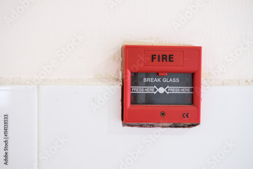 Push button switch fire or fire alarm button emergency on concrete wall.