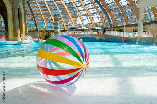 Large multi-colored beach ball in the water park swimming pool