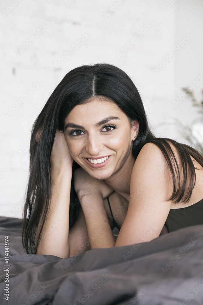 Happy girl looking at camera on bedcloth Happy girl looking at camera on bedcloth
