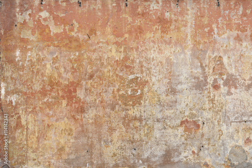 Old weathered and worn stucco wall in ochre and earth colours background