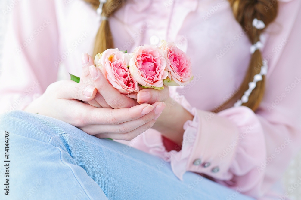 Closeup woman hands with natural manicure holding beautiful delicate branch of pink roses Closeup woman hands with natural manicure holding beautiful delicate branch of pink roses