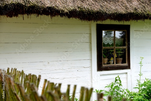 traditional country house with a wicker fence and thatched roof