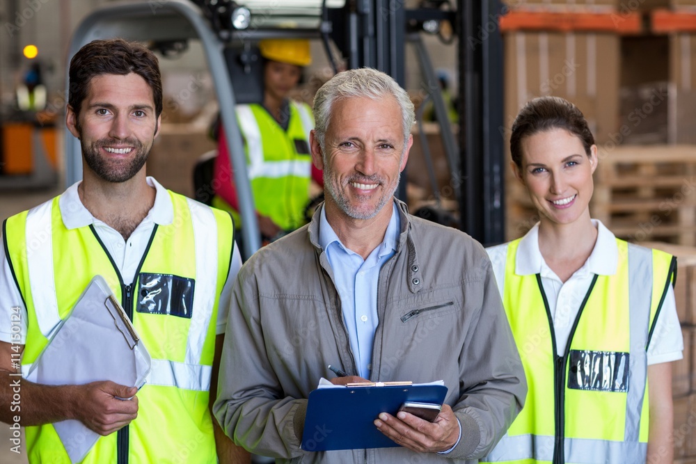 Portrait of manager is posing next to the workers and smiling Portrait of manager is posing next to the workers and smiling