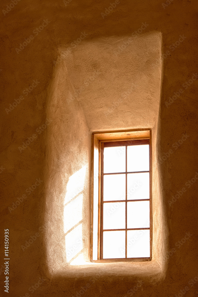 Light shining through an adobe window of a church Stock Photo | Adobe Stock