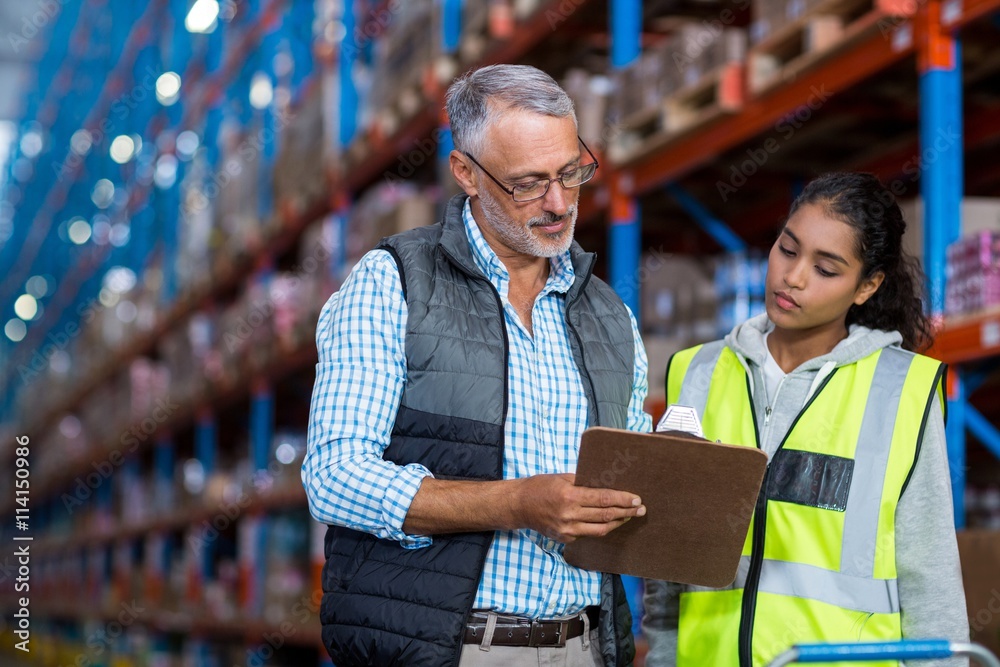 Portrait of manager is showing a clipboard to a worker Portrait of manager is showing a clipboard to a worker