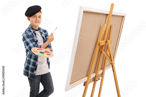 Artistic kid posing next to a canvas