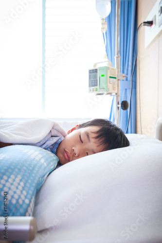Asian boy lying on sickbed. Health care and people concept.