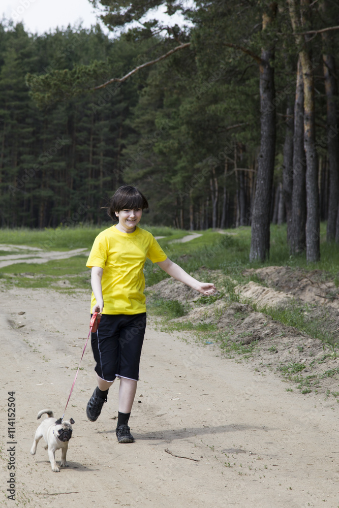 Boy walking with a dog near the forest Boy walking with a dog near the forest